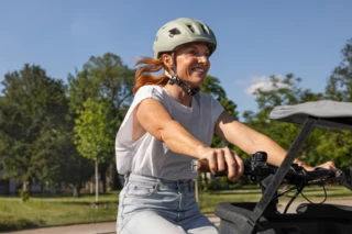 Eine Frau sitzt strahlend auf dem Ca Go FS200 Life.