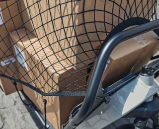 Nahaufnahme eines mit Paketen vollbeladenen FS Vario, welche mit Netzen gesichert sind.