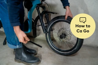 Ausgebauter Vorderreifen des Ca Go CS. Daneben steht "How to Ca Go" auf gelbem Untergrund.