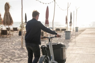Mann schiebt ein Ca Go FS Life über einen Strandweg.