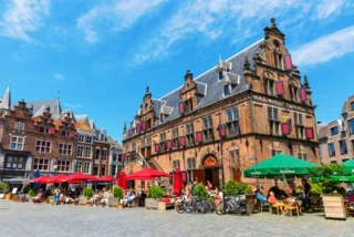 Historische gebouwen aan de Grote Markt met personen. Nijmegen is de oudste stad van Nederland.
