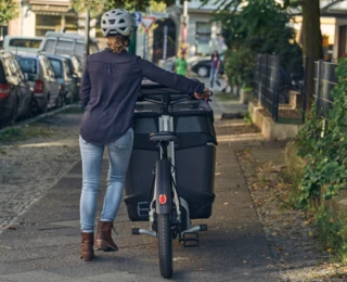 Eine Frau schiebt ein vormontiertes FS Life den Gehweg entlang.