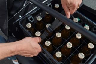 Eine Getränkekiste wird mit einem Spanngurt auf dem Ca Go FS Vario gesichert