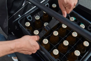 Eine Getränkekiste wird mit einem Spanngurt auf dem Ca Go FS Vario gesichert