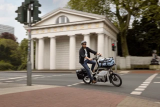 Ein Mann fährt auf einem CS über eine Straße in der Stadt.