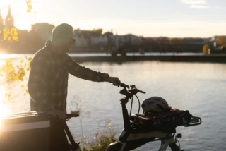 Mann steht mit Ca Go S am Ufer und schaut aufs Wasser.