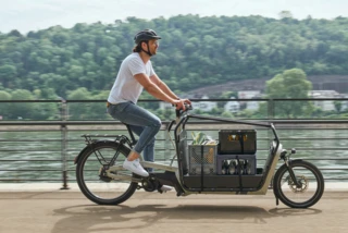 Ein Mann fährt mit einem voll beladenen FS Vario an einem Fluss entlang
