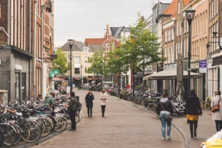 Voetgangerszone in Zwolle. Links staan veel fietsen, rechts lopen een paar mensen.
