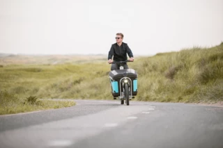 Mann fährt mit einem Ca Go FS Life über eine einsame Straße.