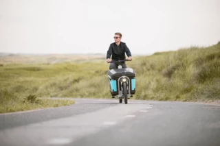Mann fährt mit einem Ca Go FS Life über eine einsame Straße.