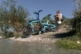 Eine Frau sitzt am Wasser. Vor ihr steht ein Ca Go CS.