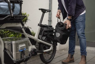 Mann befestigt Tasche am Rear Rack des Ca Go CS.