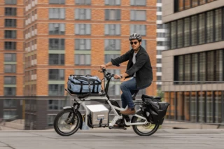 Ein Mann fährt mit einem Ca Go CS durch die Stadt.