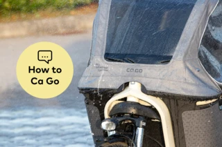 Nahaufnahme eines Nassen Ca Go FS Life Family-Plus mit All-Weather-Top. Links daneben ist ein gelber Kreis mit der Aufschrift "How to Ca Go" eingefügt.