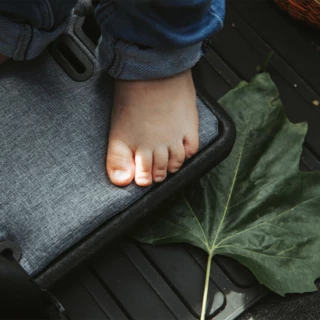 Kindersitz vom FS Life. Darauf ist ein Kinderfuß zu sehen.