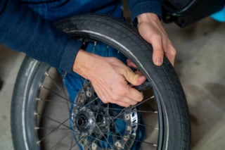 Mantel eines Fahrradreifens wird mit einem Reifenheber abgezogen