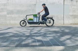Mann fährt ein FS Vario, das mit Pflanzen beladen ist.