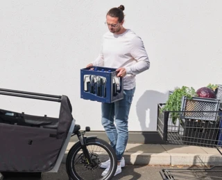 Ein Mann trägt eine Wasserkiste zum FS200 Vario