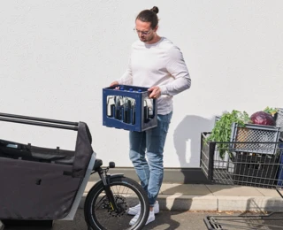 Ein Mann trägt eine Wasserkiste zum FS200 Vario