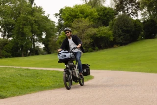 Mann fährt mit Ca Go CS durch einen Park. Das CS ist mit Taschen beladen.