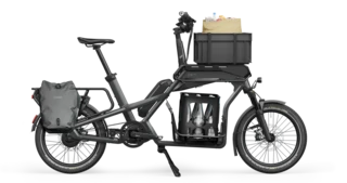 Beladenes Ca Go CS. Auf dem Front Rack steht eine Box, im Center Rack eine Wasserkiste und auf dem Real Rack sind Taschen angebracht.