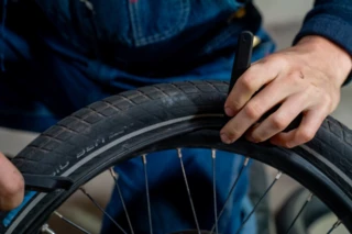 Mantel eines Fahrradreifens wird über die Felge gezogen